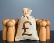 People figures stand around British pound sterling money bag.