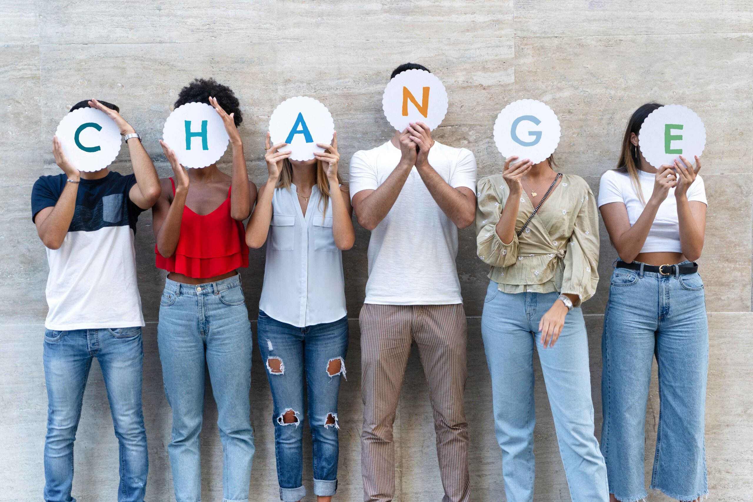 A group of young adults holding letters spelling out the word change